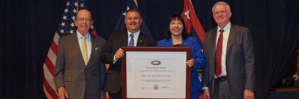 Four people holding a framed award representing VAGTC